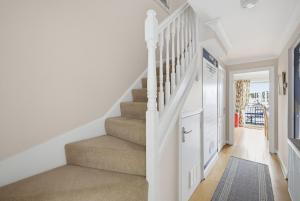 a white staircase in a home with white walls and white carpet at Marina View in Plymouth +68 photos
