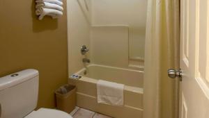 a bathroom with a tub and a toilet and a shower at Rama Inn Bells - Jackson West Hwy 412 in Bells