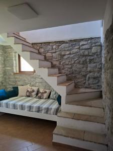a couch in a room with a stone wall at Agriturismo Cascina Lella in Varzi +75 photos