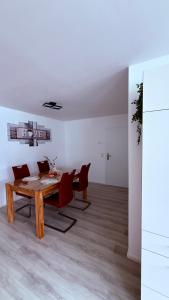 a dining room with a wooden table and red chairs at Ferienwohnung im Ellertal in Bockelnhagen +10 photos