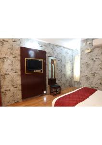 a bedroom with a bed and a tv on a wall at Anbu Grand Inn in Chidambaram +2 photos