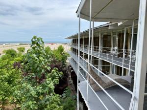 a building with a balcony with a beach in the background at Complex GEC-HISTRIA Mamaia in Mamaia