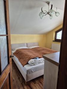 a bedroom with a bed and a chandelier at Apartmán Ružiná in Ružiná