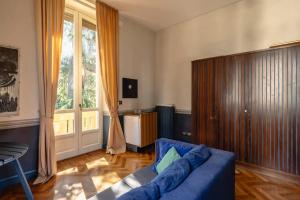 a living room with a blue couch and a window at Maison Martina in Rivoli