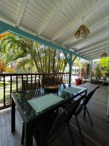 a table and chairs on the deck of a porch at Petit Havre Bleu in Le Gosier