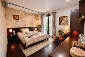a bedroom with a bed and a table in a room at The Coastal Haven pool villa in Hoi An +86 photos