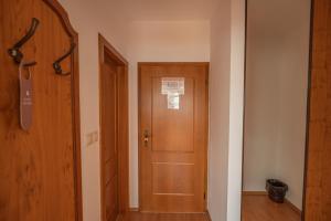 a hallway with a wooden door in a room at Penzion Tematin in Piešťany