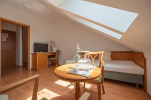 a living room with a table and a bed and a bedroom at Penzion Tematin in Piešťany