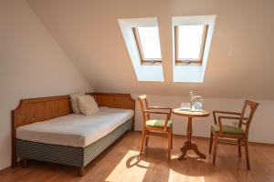 a bedroom with a bed and a table and two chairs at Penzion Tematin in Piešťany