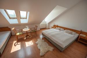 a bedroom with a bed and a table and chairs at Penzion Tematin in Piešťany