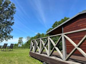 a wooden bridge next to a barn with two chairs at Vienmerjura in Benuži