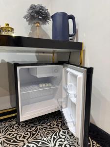 an empty refrigerator with its door open in a room at Marble Black Suite in Gloucestershire