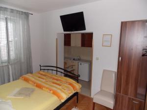 1 dormitorio con 1 cama, TV y silla en Guesthouse Villa Klaic, en Dubrovnik