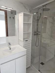 a white bathroom with a shower and a sink at DiROMANE in Braga +118 photos