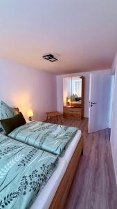 a bedroom with a bed with a green comforter at Ferienwohnung im Ellertal in Bockelnhagen