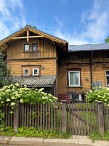 una casa di legno con una recinzione davanti di Pērles a Līgatne