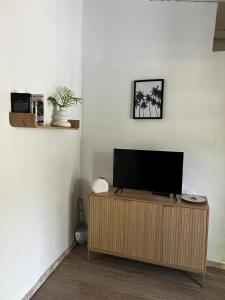 a flat screen tv sitting on top of a wooden cabinet at Petit Havre Bleu in Le Gosier