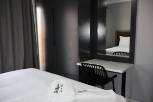a bedroom with a mirror and a bed and a chair at The Ulysses Motel in Ga-Mothiba
