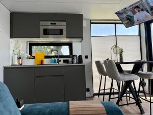 a kitchen with a sink and a table with chairs at Luxury Houseboat Wolphaartsdijk VP109 in Wolphaartsdijk