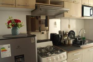 a kitchen with a stove and a vase of flowers at Cesar's Apartment - Los Laureles in Lima