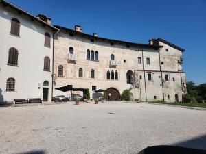 a large stone building with a courtyard in front of it at Il Pozzo dei Desideri Vintage in Spilimbergo
