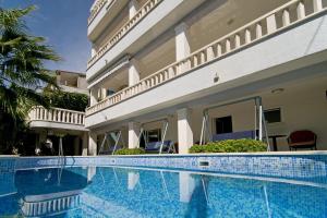 a swimming pool in front of a house at Dizma Welness Apartmani in Duće