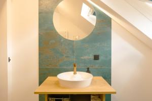a bathroom with a sink and a mirror at Geidorf Residenz - Serviced Apartments & Parking in Graz +74 photos