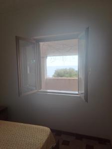 a window in a bedroom with a bed and a view at Villette Pepe in Coccorino