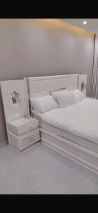 a white bed with two pillows and a night stand at الصفا in Jeddah