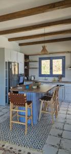 a kitchen with blue cabinets and a table and chairs at Villa Magiko in Poros