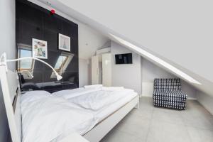 a white bedroom with a bed and a chair at Jantar Park in Jantar