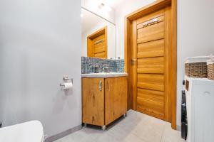 a bathroom with a sink and a wooden door at Jantar Park in Jantar +12 photos