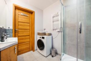 a bathroom with a washing machine and a shower at Jantar Park in Jantar