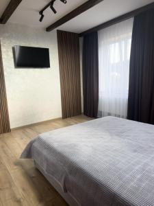 a bedroom with a bed and a television on the wall at Gofahouse in Verkhovyna