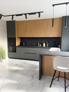 a kitchen with wooden cabinets and a table and chairs at Gofahouse in Verkhovyna