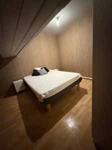 a bedroom with a bed in the corner of a room at Kimloge in Le Portel