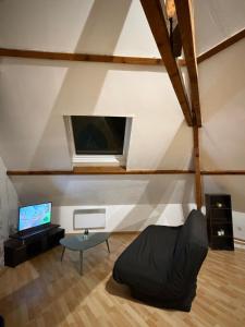 a living room with a couch and a tv at Kimloge in Le Portel