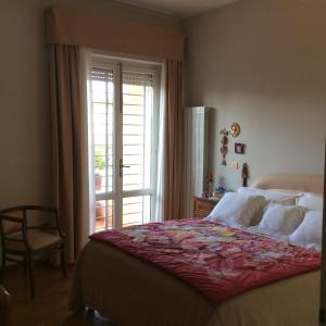 a bedroom with a large bed and a window at Casa Adele in Lido di Camaiore