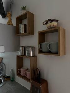 una cucina con mensole di legno sul muro di Pērles a Līgatne