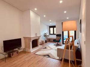 a living room with a tv and a fireplace at Retiro do Lago in Ferreira do Zêzere