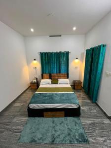 a bedroom with two beds and green curtains at Coffee dale in Kalpetta