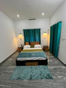 a bedroom with two beds and green curtains at Coffee dale in Kalpetta +4 photos