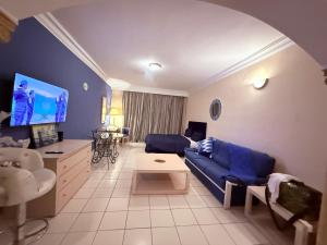 a living room with a blue couch and a table at Yasmina Hotel Appartment in Yasmine