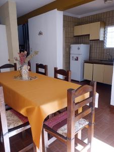 a kitchen with a yellow table with chairs and a refrigerator at Casa Rodas in Goya