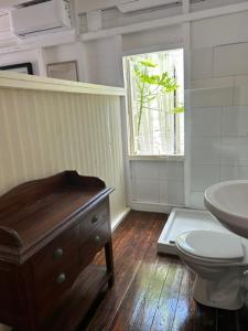 a bathroom with a sink and a toilet and a window at Casa Papaya in Marigot