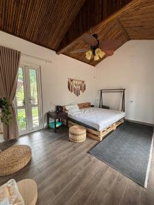 a bedroom with a bed and a ceiling fan at Chậm Viên Le Jardin in Thanh Lâm