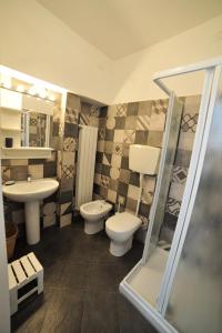 a bathroom with two toilets and a sink and a shower at Erasmo Rooms & Breakfast in Finale Ligure