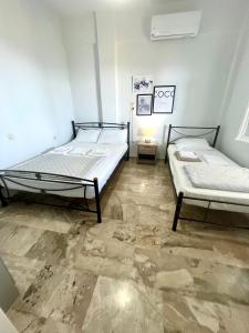 two beds in a room with marble floors at Τequila Sunrise in Áyios Pétros
