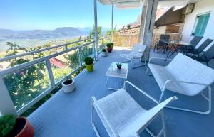 a balcony with white chairs and a table and a view at Τequila Sunrise in Áyios Pétros