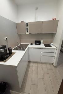 a small kitchen with white cabinets and a sink at Matera Central Nest in Matera